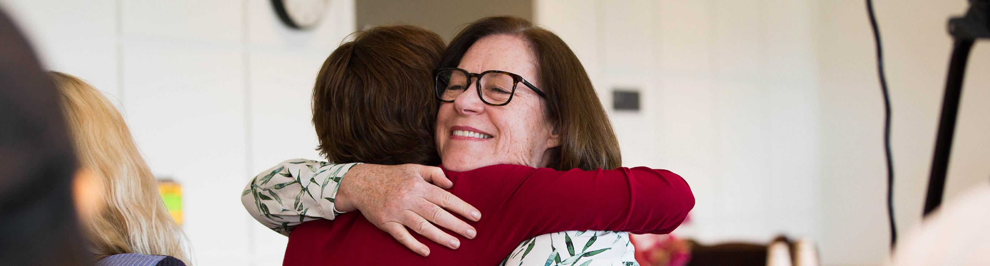former caregiver hugs Margaretta Page, nurse coordinator for the UCSF Caregiver Program