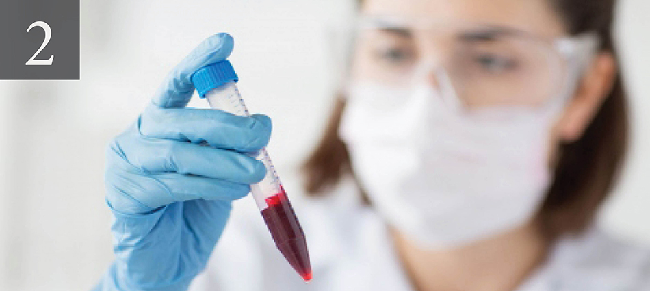 scientist examines a vial of blood