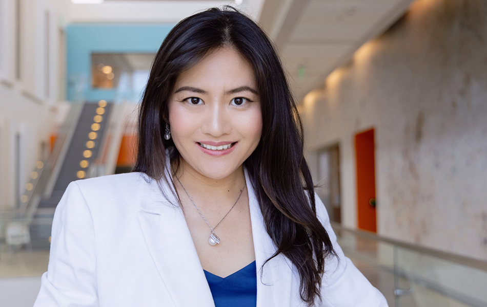 Rongze "Olivia" Lu, PhD, stands in the hallway on the 4th floor of the Helen Diller Family Cancer Research Building.