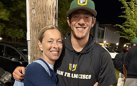 Liz Holzemer, the founder of Meningioma Mommas, hugs her son, Hunter, who is wearing his a USF cap and hoodie.