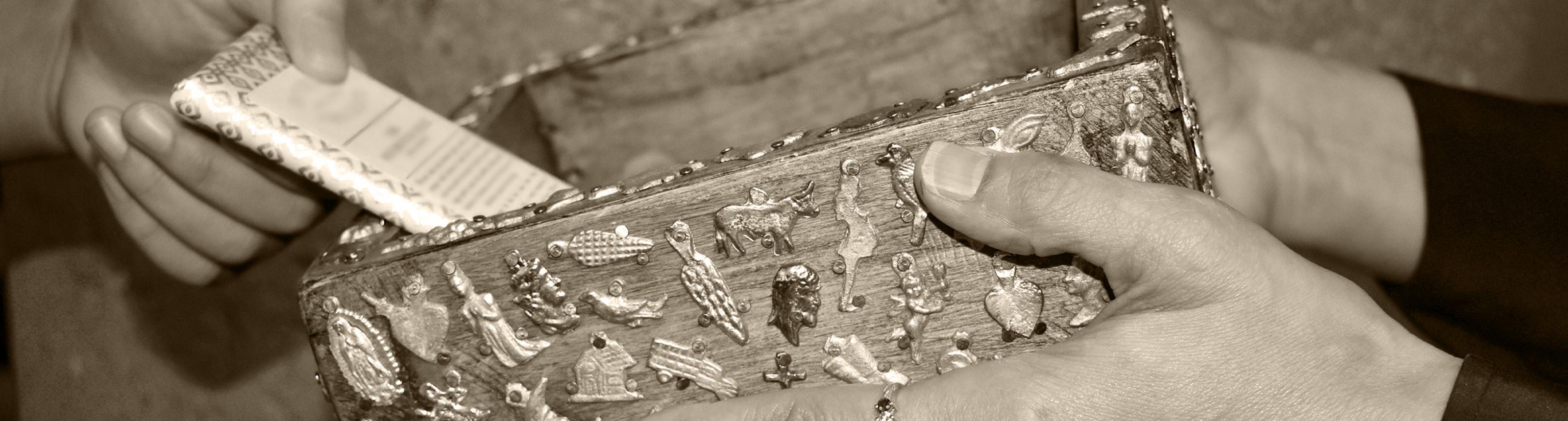 close-up of hands passing an offering box