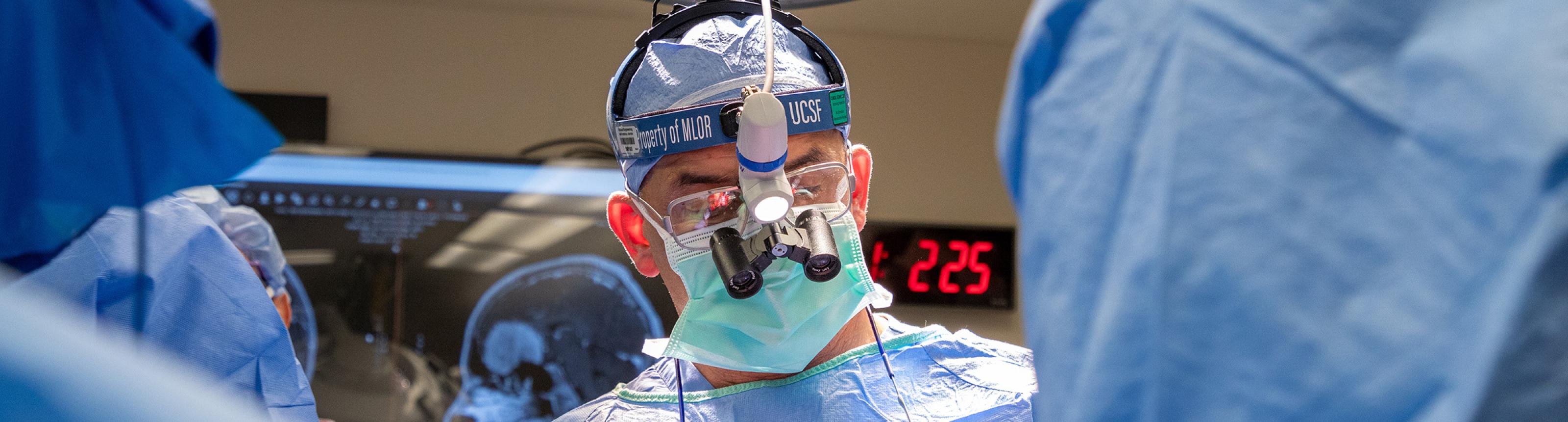 A neurosurgeon in the operating room performing a surgery to remove a tumor