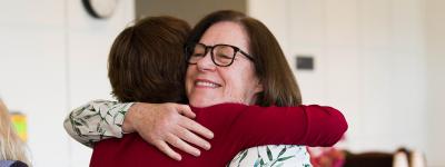Caregiver hugs Margaretta Page at the annual UCSF Caregiver Retreat